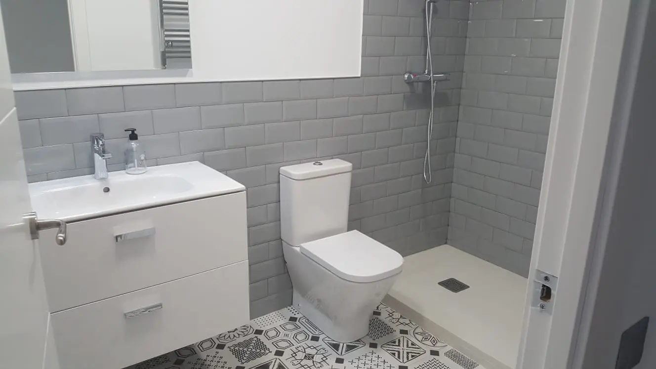 Baño con azulejo metro gris, suelo hidráulico y ducha a ras de suelo