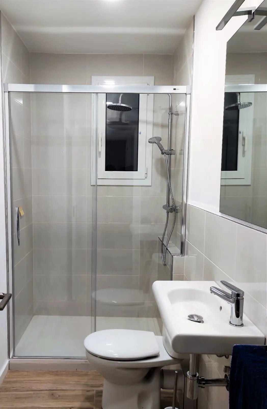 Baño pequeño con plato de ducha, mampara corredera y columna de ducha