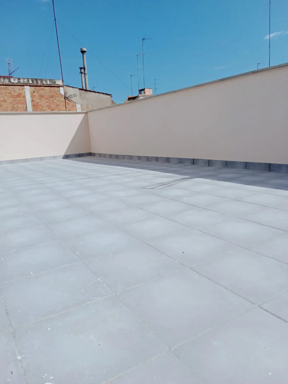 Terraza de azotea impermeabilizada con baldosa nueva y petos pintados